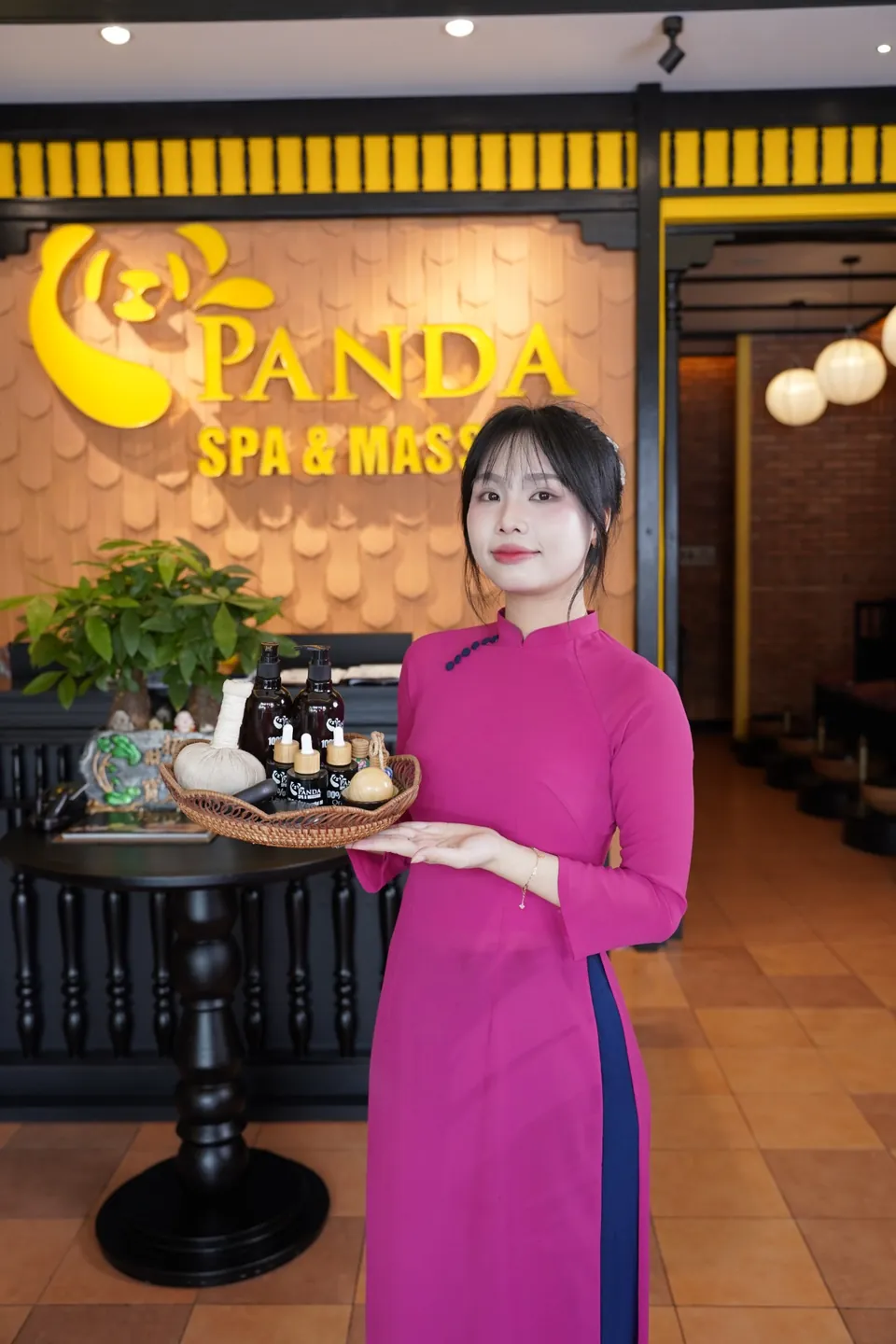 Kỹ thuật viên Panda Spa mặc áo dài đón khách tại quầy lễ tân